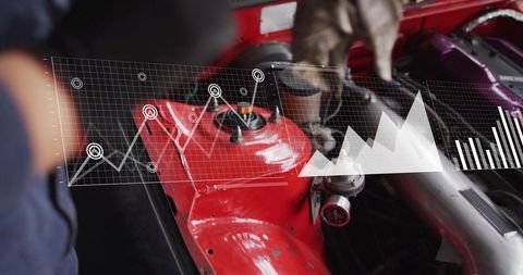 Mechanic Diagnosing Engine with HUD Telemetry Overlay Showing Performance Graphs over Red Strut Towe