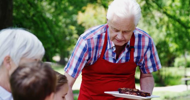 Senior Man Serving Barbecue at Family Picnic in Park - Download Free Stock Images Pikwizard.com