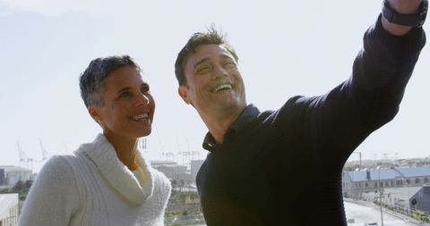 Joyful Middle-Aged Couple Taking Selfie Outdoors with Copy Space