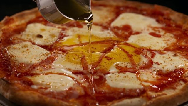 Pizza with runny egg yolks and olive oil drizzle on melted mozzarella and chili