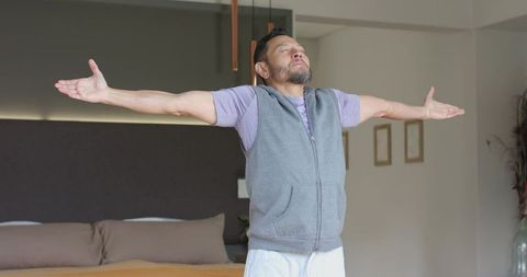 Mature Asian Man Enjoying Stretch in Modern Bedroom