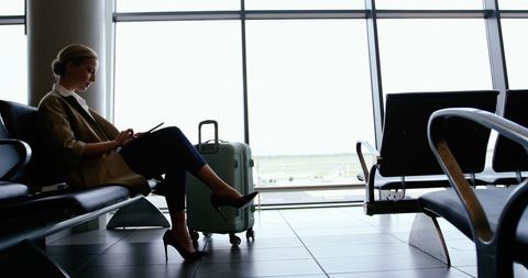 woman using digital tablet at airport - Download Free Stock Images Pikwizard.com