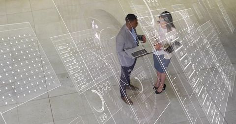 Business professionals collaborating with AR data overlays in modern lobby