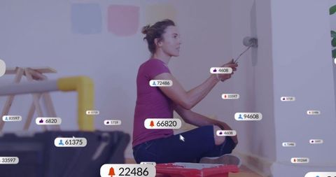 Woman Engaging in DIY Wall Painting Surrounded by Social Media Icons