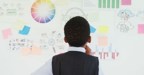 Young Businessman Analyzing Strategic Plans and Colorful Charts