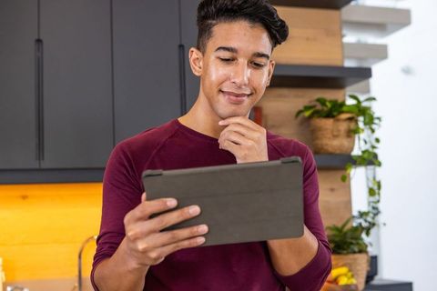 Man using tablet in modern kitchen for lifestyle and technology ideas