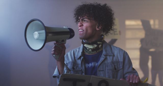 Young protester passionately speaking through megaphone at an outdoor rally. Perfect for themes of activism, social justice movements, public demonstrations, and youth engagement.