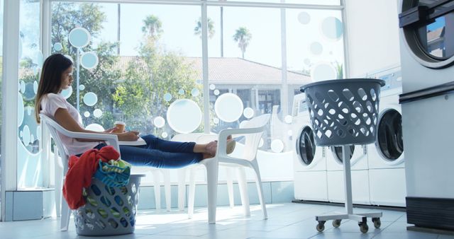 Woman Relaxing in Laundromat with Laundry Baskets - Download Free Stock Images Pikwizard.com