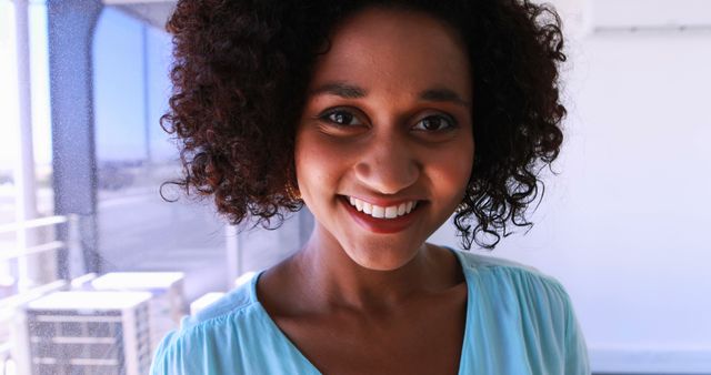 Smiling Woman with Curly Hair Posing in Bright Casual Setting - Download Free Stock Images Pikwizard.com