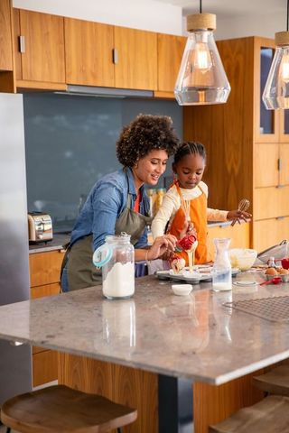 Mother and Daughter Experiencing Joyful Baking Together in Modern Kitchen