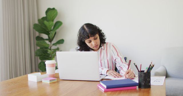 Focused Young Woman Studying at Home with Laptop and Notebooks - Download Free Stock Images Pikwizard.com