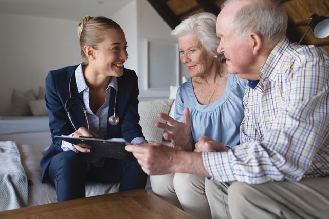 Female doctor holding clipboard and engaging in a detailed discussion with an elderly couple at their home. Ideal for illustrating themes related to home healthcare, elder care services, and medical consultations at home. Can be used in healthcare publications, websites, or advertisements promoting medical services for seniors.