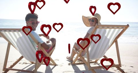 Diverse Couple Relaxing in Deckchairs on Sunny Beach