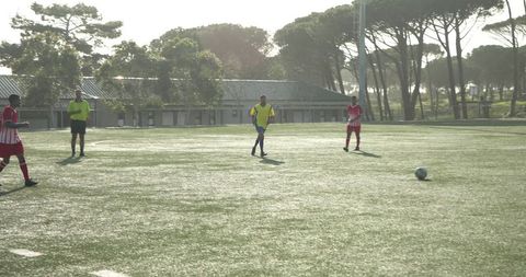 Soccer players competing intensely on sunny outdoor field