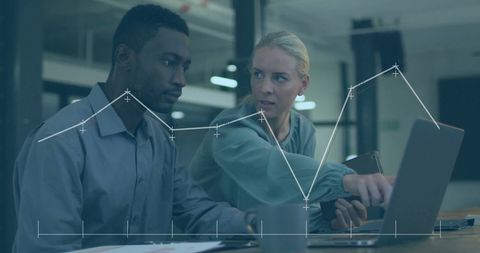 Diverse Colleagues Analyzing Financial Data at Modern Workspace