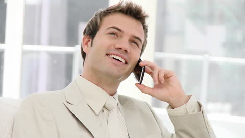 Confident Businessman Talking on Mobile Phone in Modern Office