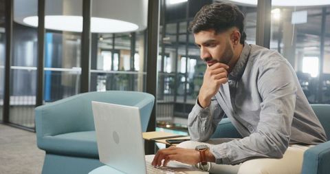 Professional Man in Modern Office Lounge Working on Laptop