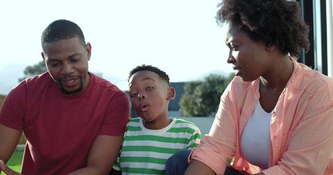 African american family sharing playful moment on porch with child making silly face