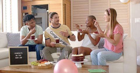 Friends Celebrate New Job with Cake and Champagne in Cozy Living Room