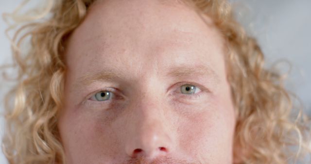 Close-Up of Man with Curly Blonde Hair and Light Green Eyes - Download Free Stock Images Pikwizard.com