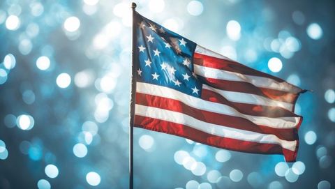 American flag waving heroically with sparkling light bokeh