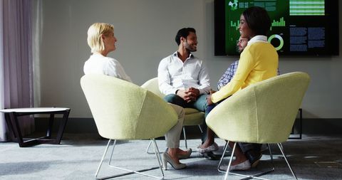 Diverse Team Engaging in Office Meeting Seated in Modern Chairs