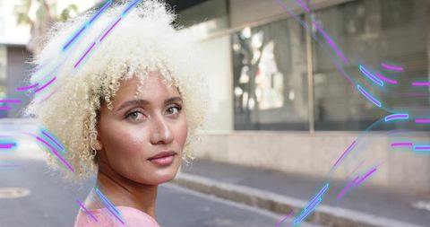 Elegant Woman Flaunting Curls Amid Neon Urban Vibes