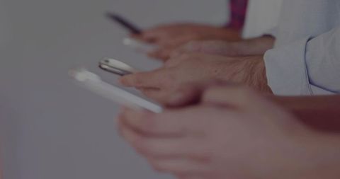 Business Professionals Engaging with Smartphones in Meeting Setting