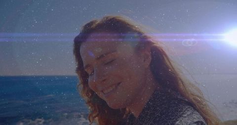 Woman Enjoying Coastal Breeze with Sun Flare