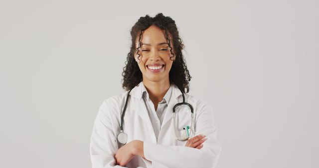 Image of portrait of smiling biracial female doctor with arms crossed. global medicine and healthcare concept.
