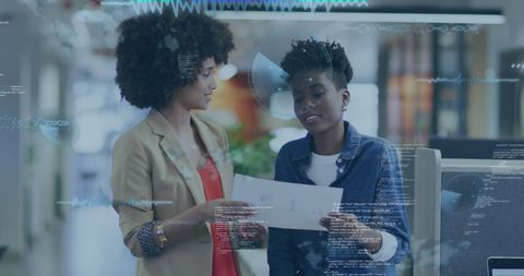African american businesswomen analyzing financial data in modern office