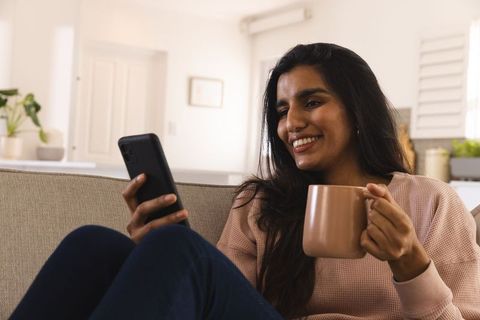 Young Asian Woman Enjoying Relaxation on Comfortable Sofa at Home