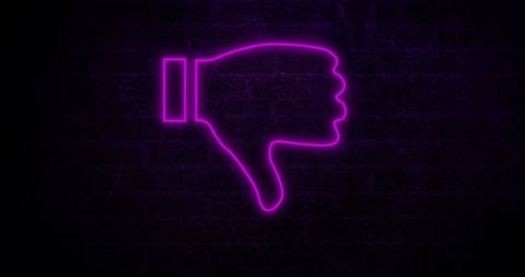 Red neon thumbs down symbol on brick wall