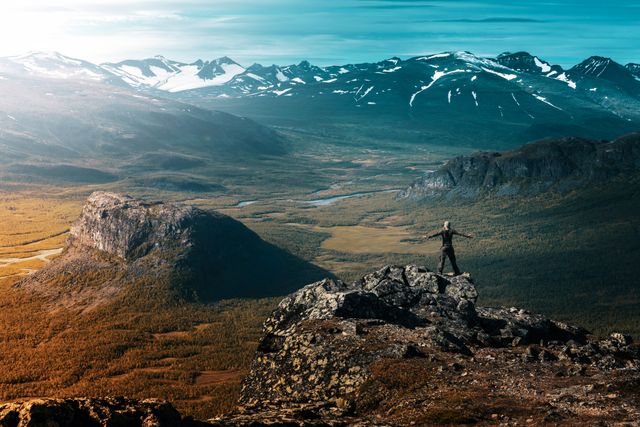 Man Standing on High Rock Overlooking Mountainous Landscape - Download Free Stock Photos Pikwizard.com