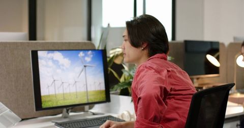 Businessman Analyzing Clean Energy Solutions on Desktop Monitor