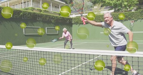 Senior Couple Playing Tennis On Sunny Outdoor Court
