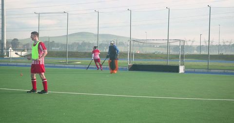 Teenage Field Hockey Athletes Practicing Near Goal