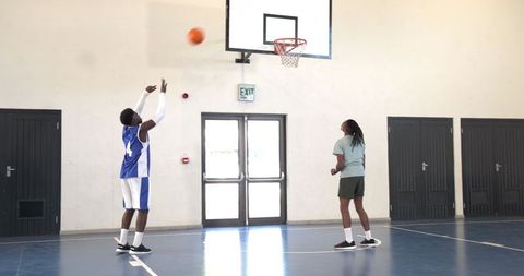 Young Athletes Practicing Basketball Jump Shot on Indoor Court