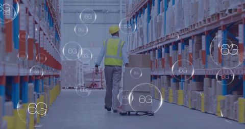 Warehouse worker pulling pallet jack with boxes in smart 6g connected logistics hub