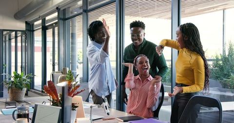 Diverse Team Celebrating Success in a Modern Office Setting