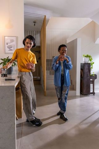 Diverse couple enjoying coffee in modern open-plan kitchen with minimalist concrete floors