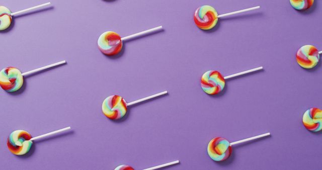 Cheerful and vibrant, this image shows colorful lollipops arranged in a repetitive pattern on a purple background. Great for use in candy or sweets advertising, children's party invitations, festive decorations, or as a fun, eye-catching background design.