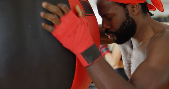 Boxer in Red Headband and Wraps Resting on Punching Bag - Download Free Stock Images Pikwizard.com