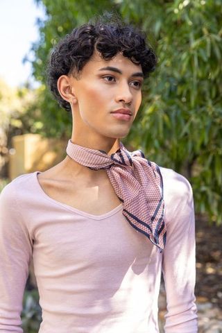 Fashionable Individual in Sunlit Garden with Scarf and Earring