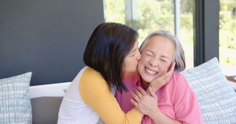 Joyful Senior Woman Enjoying Warm Care at Home with Family Member