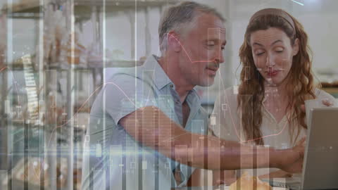 Coworkers Analyzing Financial Graphs on Laptop