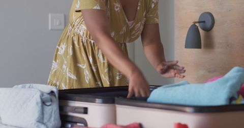 Woman Packing Clothes Into Suitcase for Travel Adventure