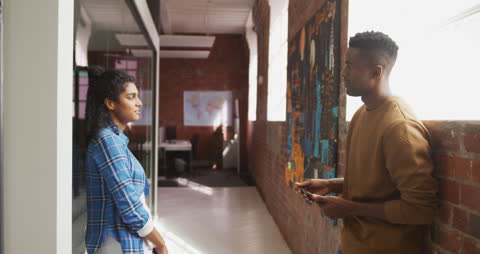 Diverse Coworkers Engaging in Office Hallway Discussion