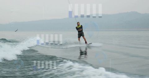 Man Wakeboarding on Calm Lake Wearing Neon Life Vest