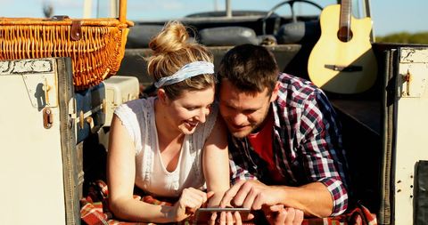 Couple Relaxing in Hot Air Balloon with Tablet and Guitar